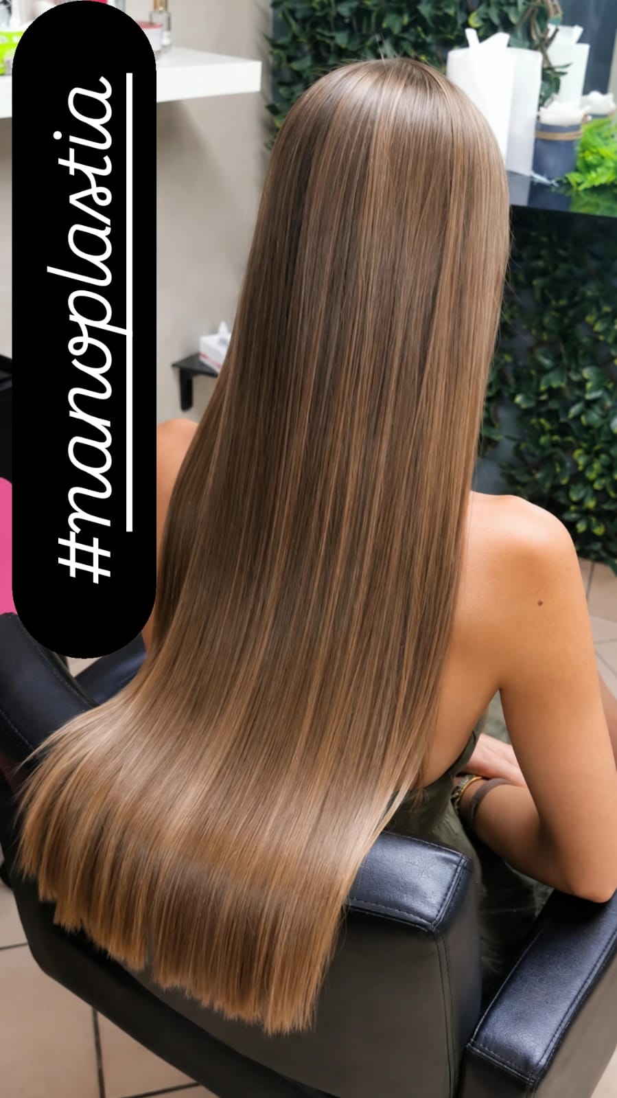 Rear view of a seated person with long, straight brown hair, framed in a chair with a vertical promotional text overlay and bright indoor lighting.